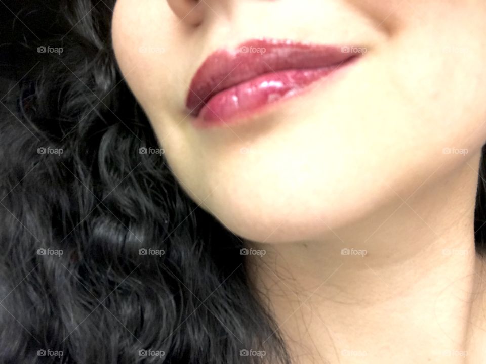 Glossy cherry lipstick on female brunette 