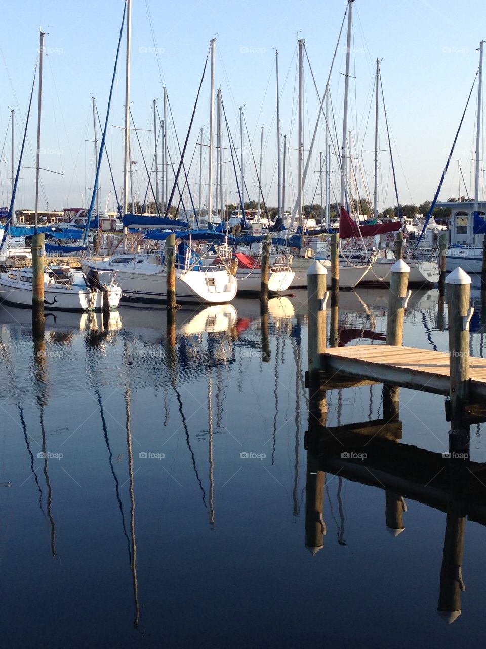 Reflection of boats and dock on the water at a marina