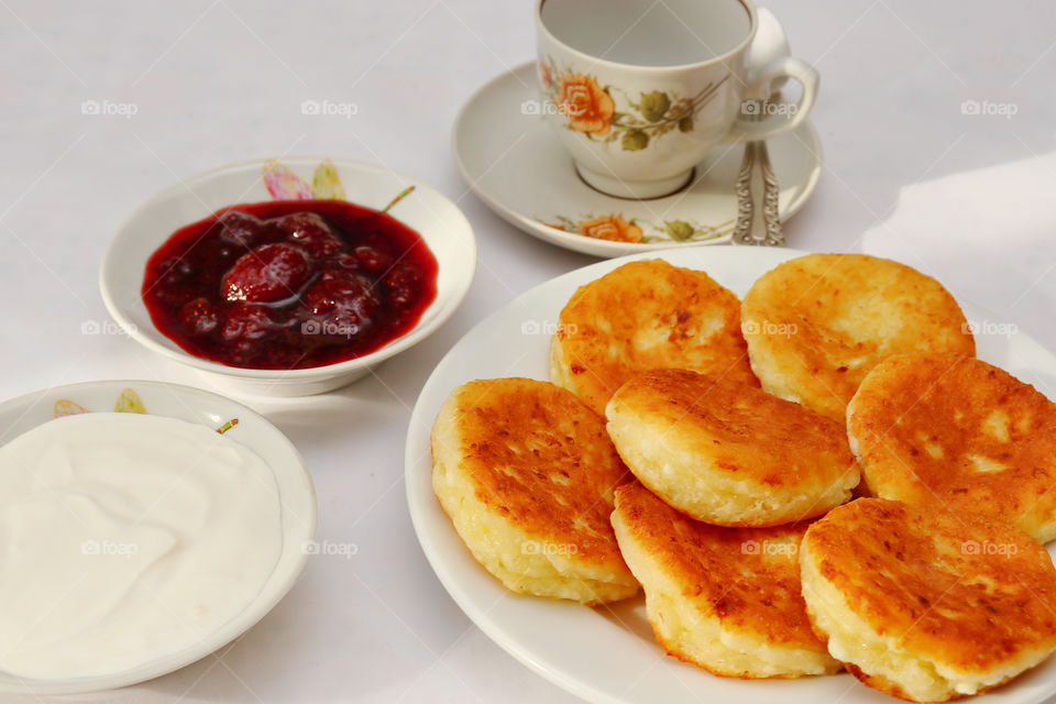 Fragrant ruddy golden with a brown crust freshly cooked syrup curds with strawberry jam and sour cream piping hot is an amazingly delicious addition to morning coffee.