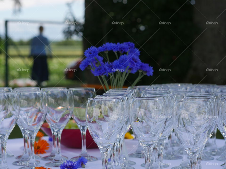 Champagne glasses empty on table with blue cornflower batchelor's button