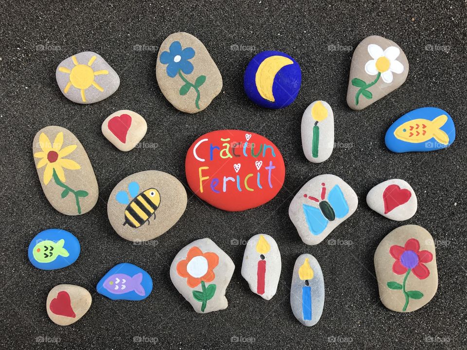 Craciun Fericit, romanian Merry Christmas message with stones design over black sand 