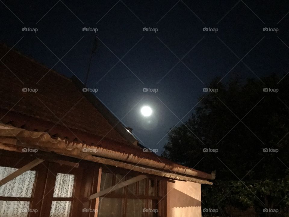 Moon above the roof of the house.