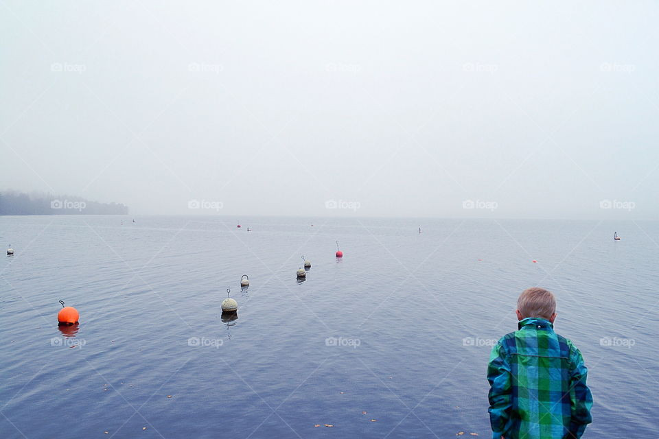 Boy at a mist lake