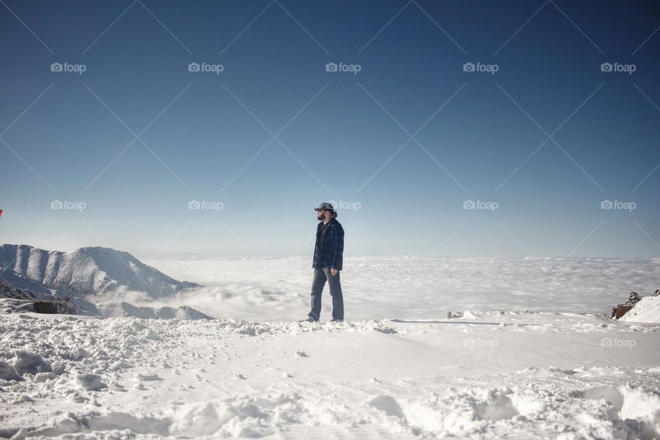 A man on a mountain above the clouds