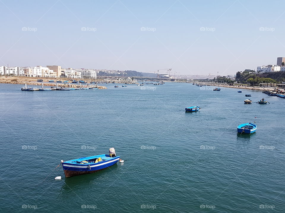 boat beach sea Morocco blue sky buildings mosque city clouds sky skys cloud view of the old city