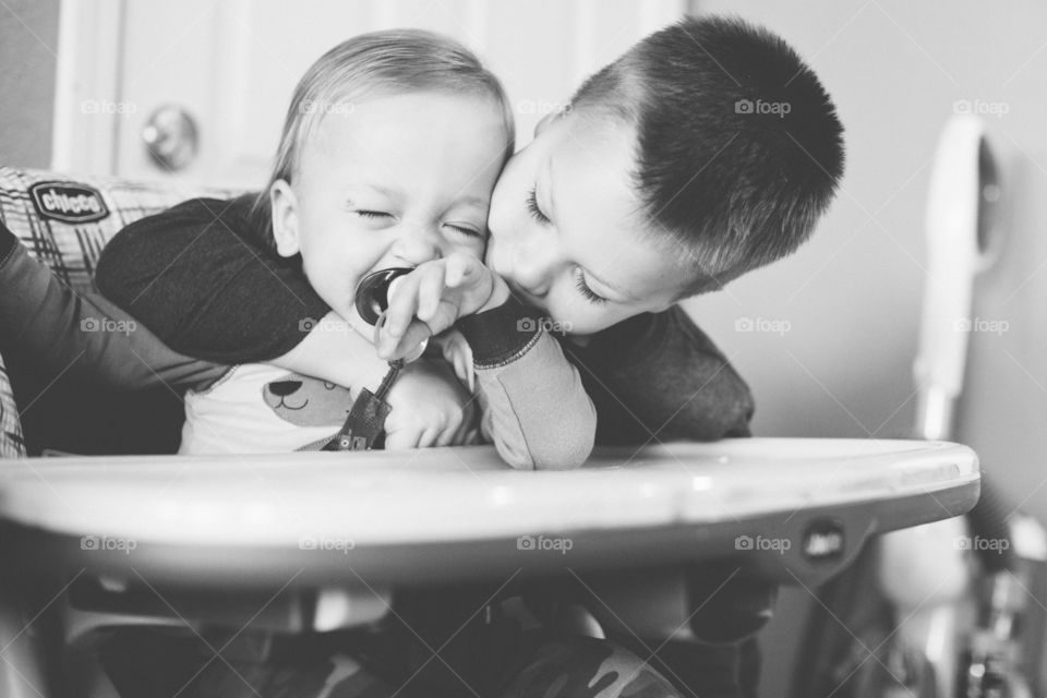 Oldest brother showing affection to younger brother laughing 