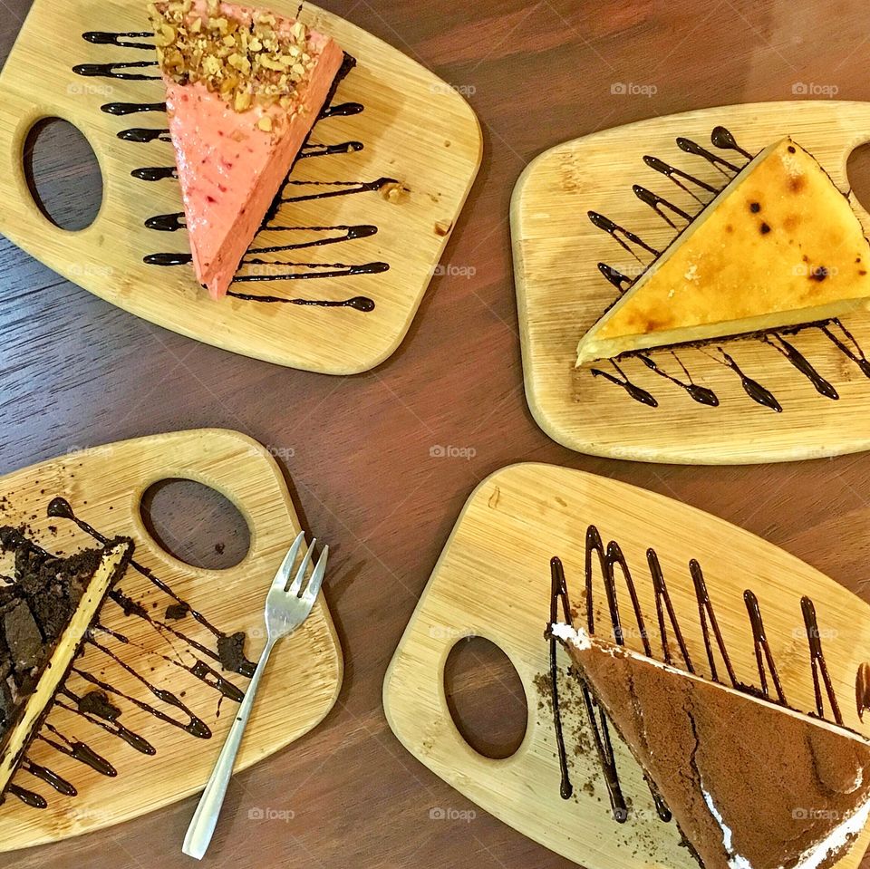 Different cheesecakes on wooden plate