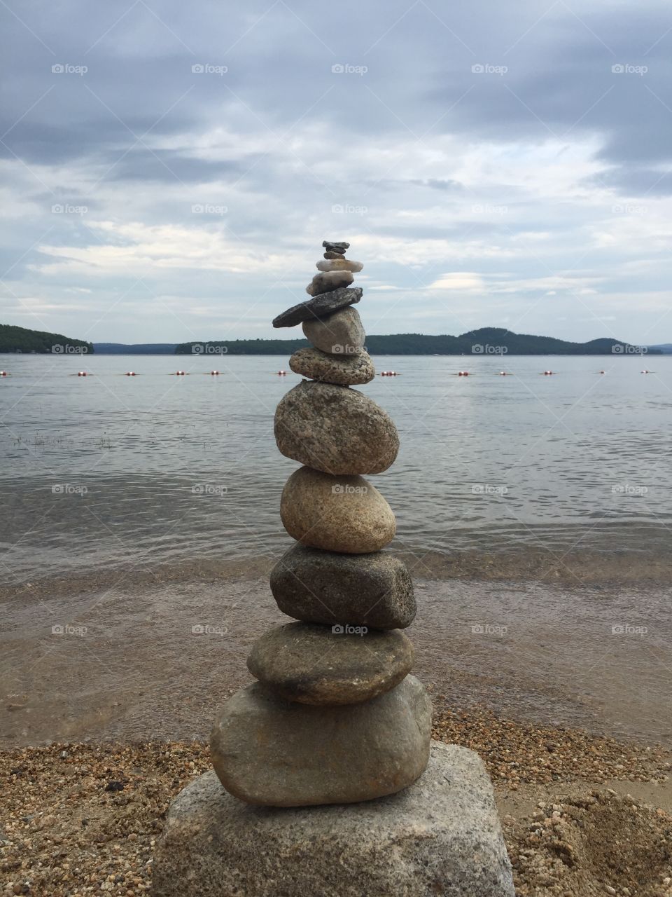 Stack of rocks cairn along beach by lake winnipesaukee New Hampshire 