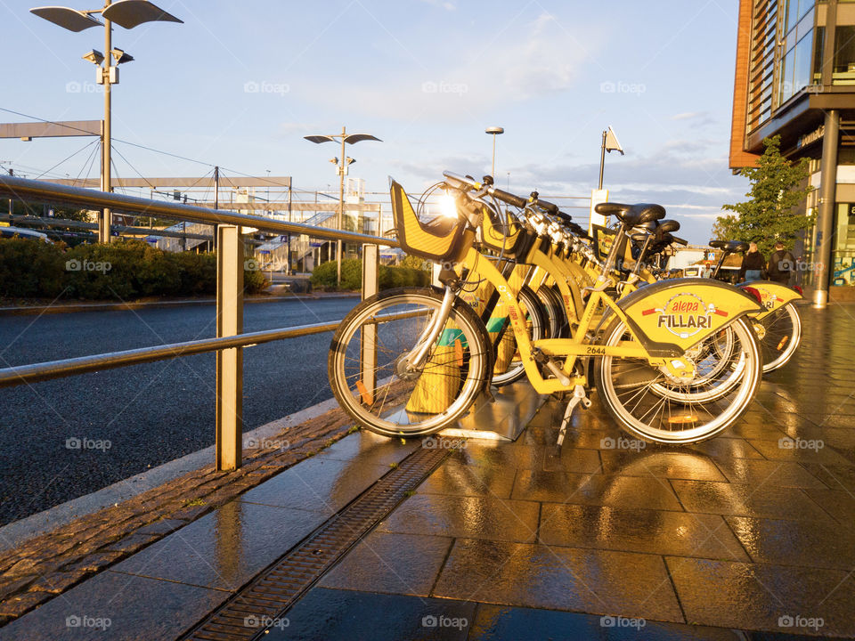 Espoo, Finland - August 9, 2019: Yellow city bikes parked at sidewalk by the Sello shopping mall in Leppävaara district of Espoo. City bikes are alternative means of public transportation in Helsinki metropolitan area.