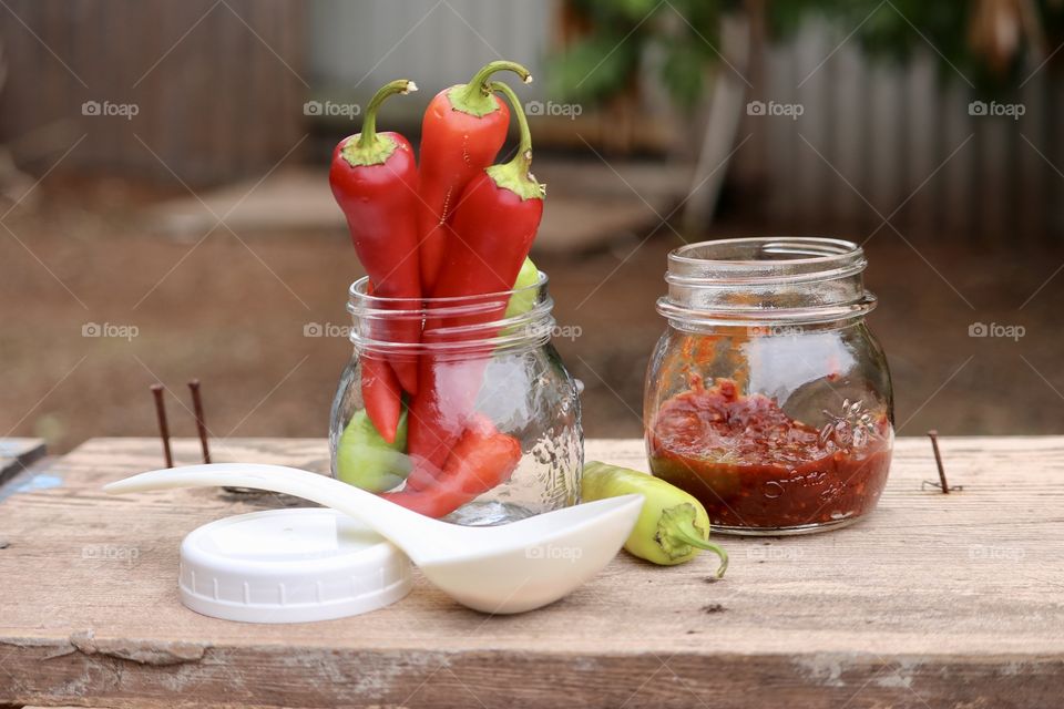 Farm fresh organic peppers capsicum chopped and preserves as condiment, rustic outdoor image pint jar, white ladle, fresh produce 