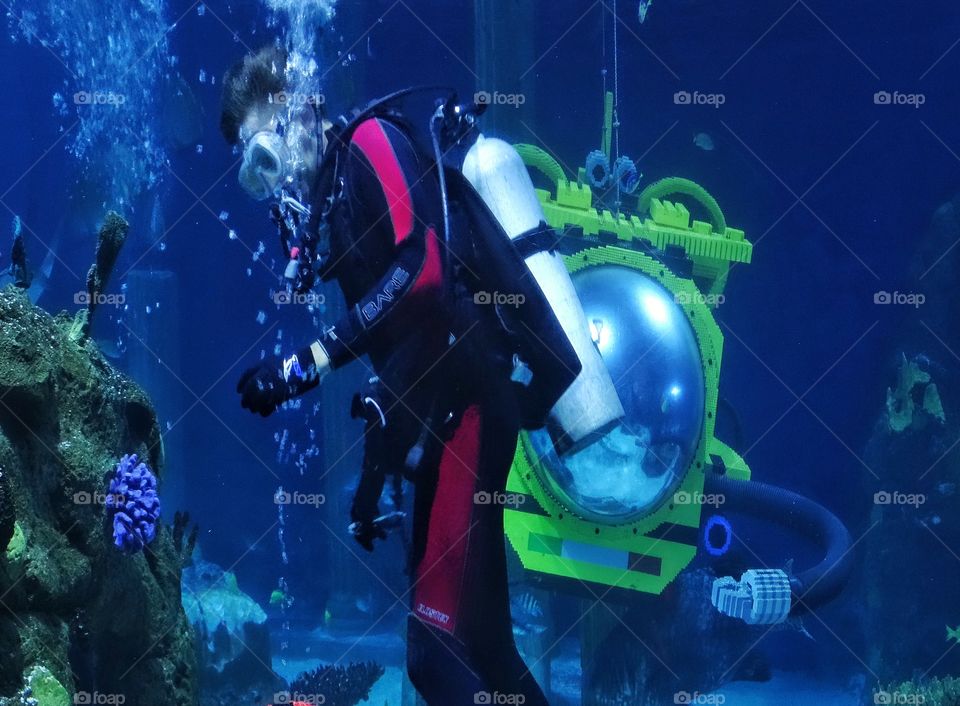 Underwater Exploration. Scuba Diver In Coral Reef With Yellow Submarine
