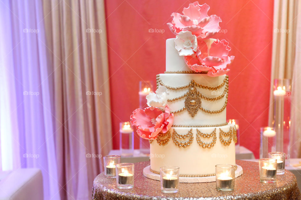 Culturally decorated cake with gold, cream colours, and massive flowers, beautiful