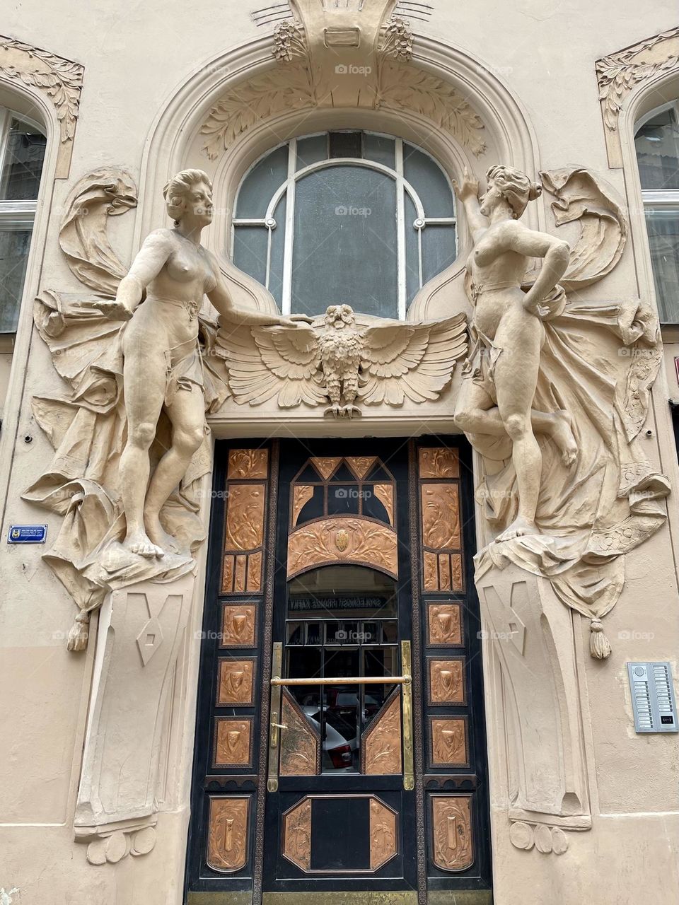 Statues of beautiful women above the entrance door, view bottom to the top