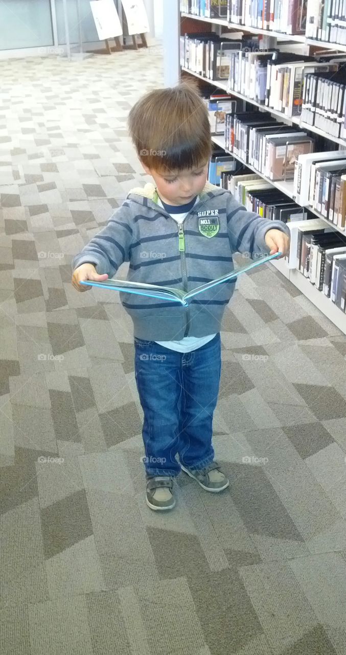 Little Boy Loving to Read at the Library