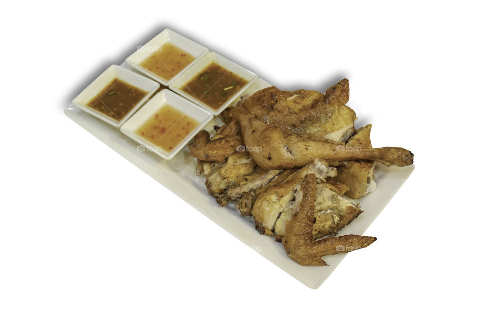 Isolated Grilled chicken with spices in the dish on a white background with clipping path.