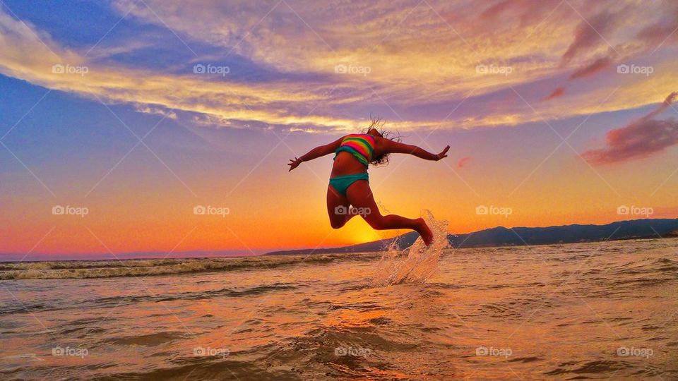 Girl jumping by the beach