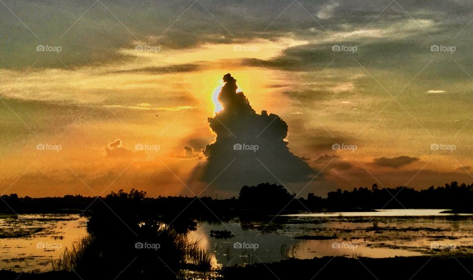 Sunset behind the cloud mountain reflecting on the lake 