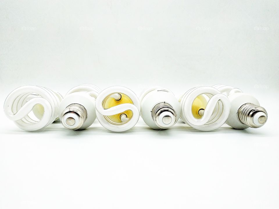 six energy-saving light bulbs lined in a row on a white background
