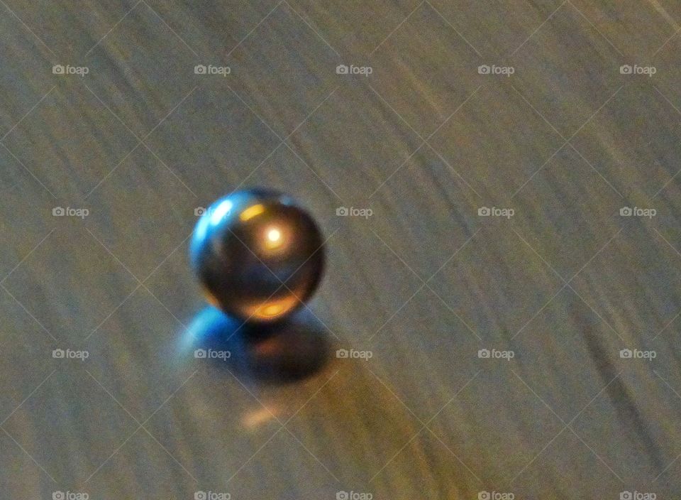 Rolling Ball. Shiny Metal Ball Bearing Rolling On A Steel Surface