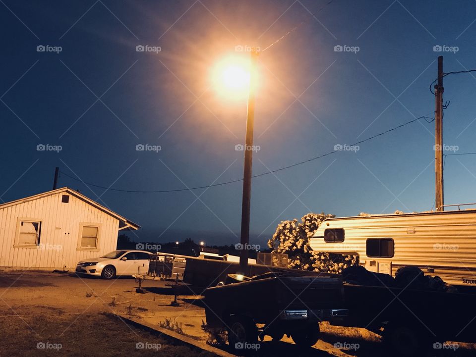Farmer things in the farm at night with the light post. 