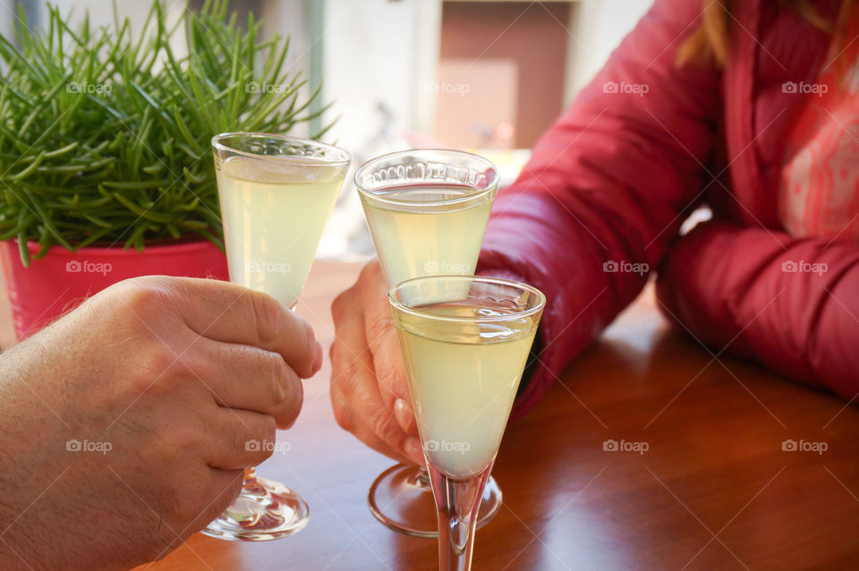 Man and woman holding limoncello shots