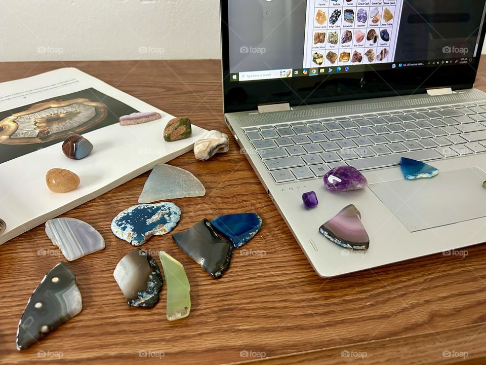 Rocks on a desk with a book and laptop