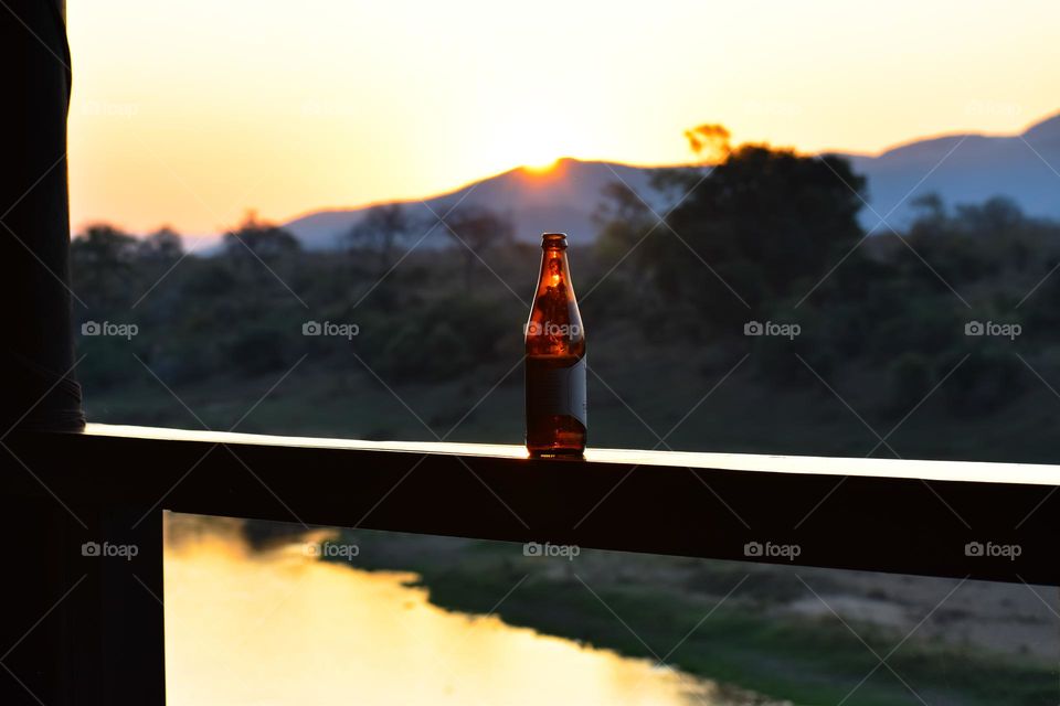 Enjoying drinks on the deck next to the river in the bush while watching the sunset.