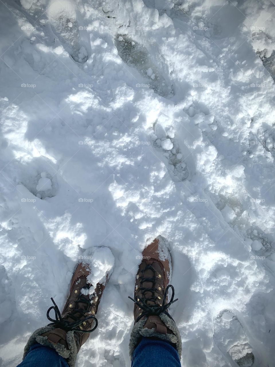 A person standing on the snow wearing boots 