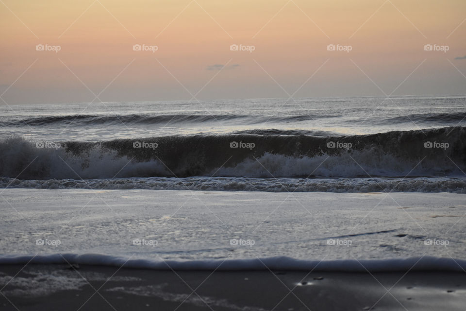 beach at dusk with foamy waves