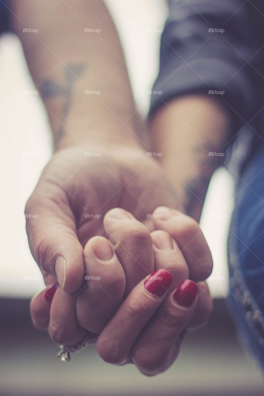 Close up of hands of a couple holding each other’s hands