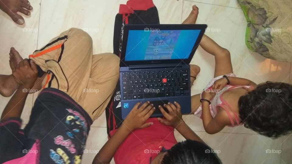 child operating  in laptop playing games