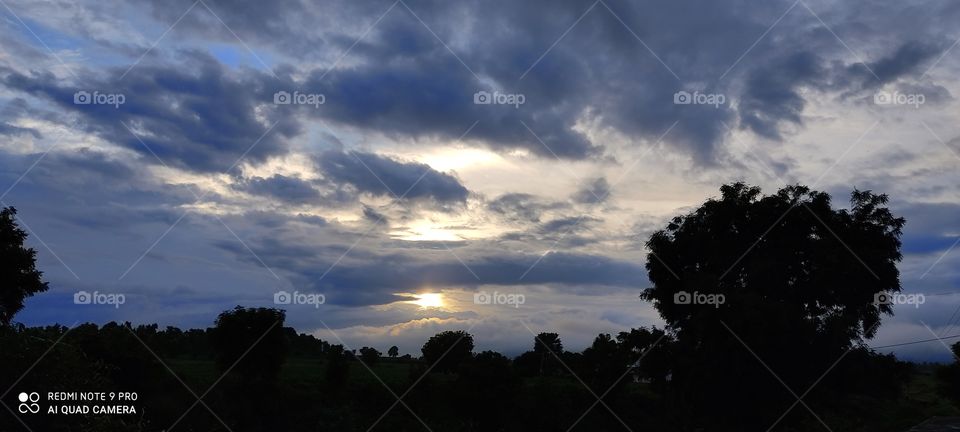 The sun hiding in the clouds looks like someone is blowing fire
