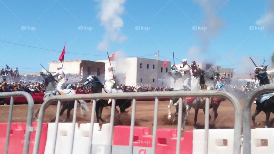 Horseback riders shoot from their guns