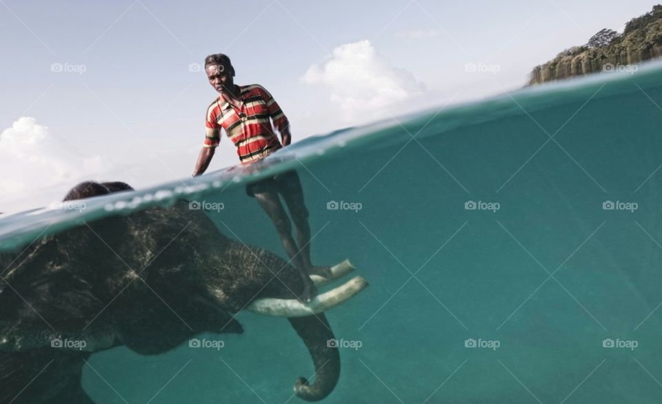 Nazroo, a mahout (elephant driver), poses for a portrait while taking his elephant, Rajan, out for a swim in front of Radha Nagar Beach in Havelock, Andaman Islands. Rajan is one of the few elephants in Havelock that can swim, so when he is not dragg
