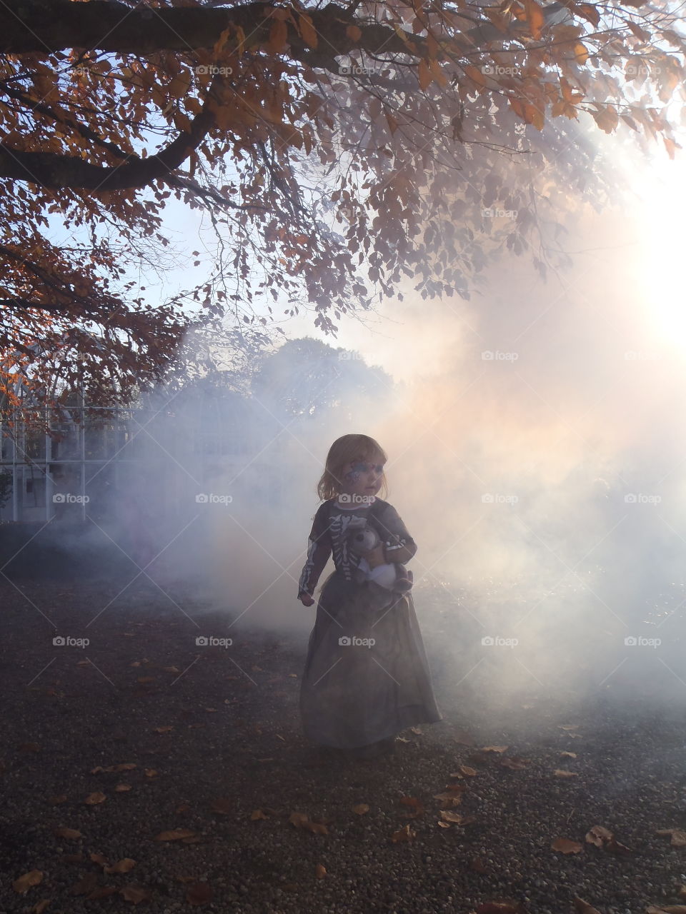 Cute girl standing under tree during autumn