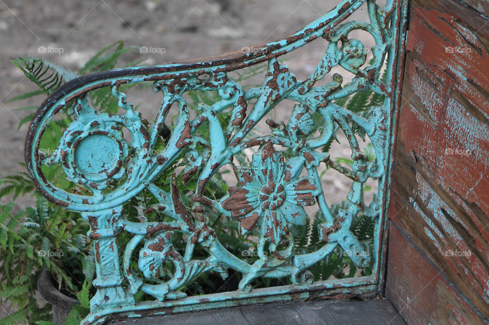 Texture & pattern: The patterned metal arm of a wooden bench has either been deliberately distressed or age has naturally created a beautiful rust & turquoise patina. In addition the distressed wood of the bench gives it a very vintage appearance. 
