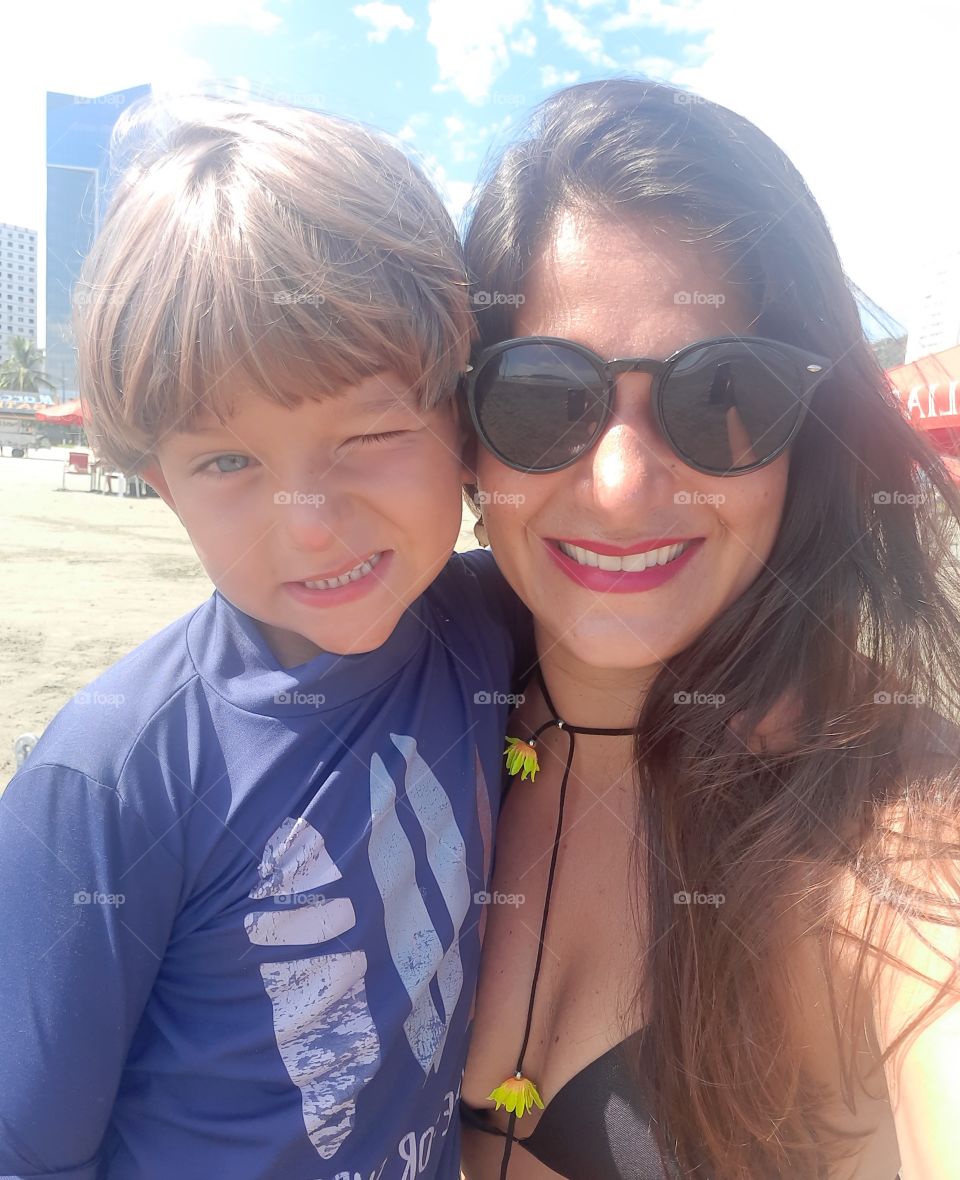 smiling mother and son winking on the beach