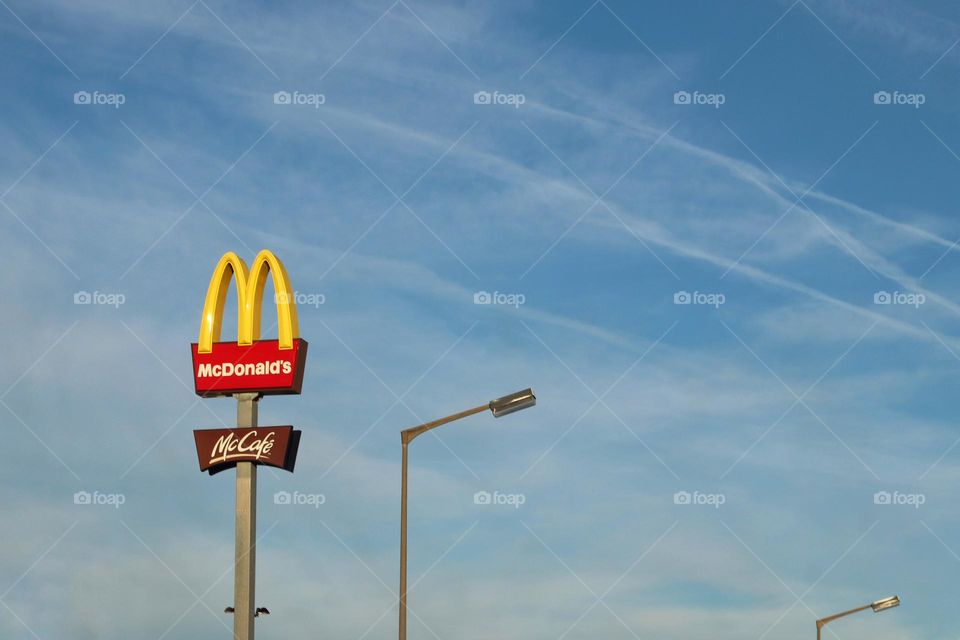 McDonald's sign next to street lamp on blue sky