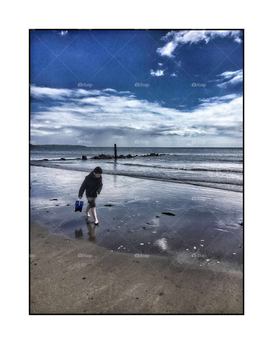 Small boy walking on sandy beach
