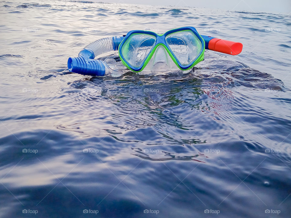 a diving mask surrounded by the sea