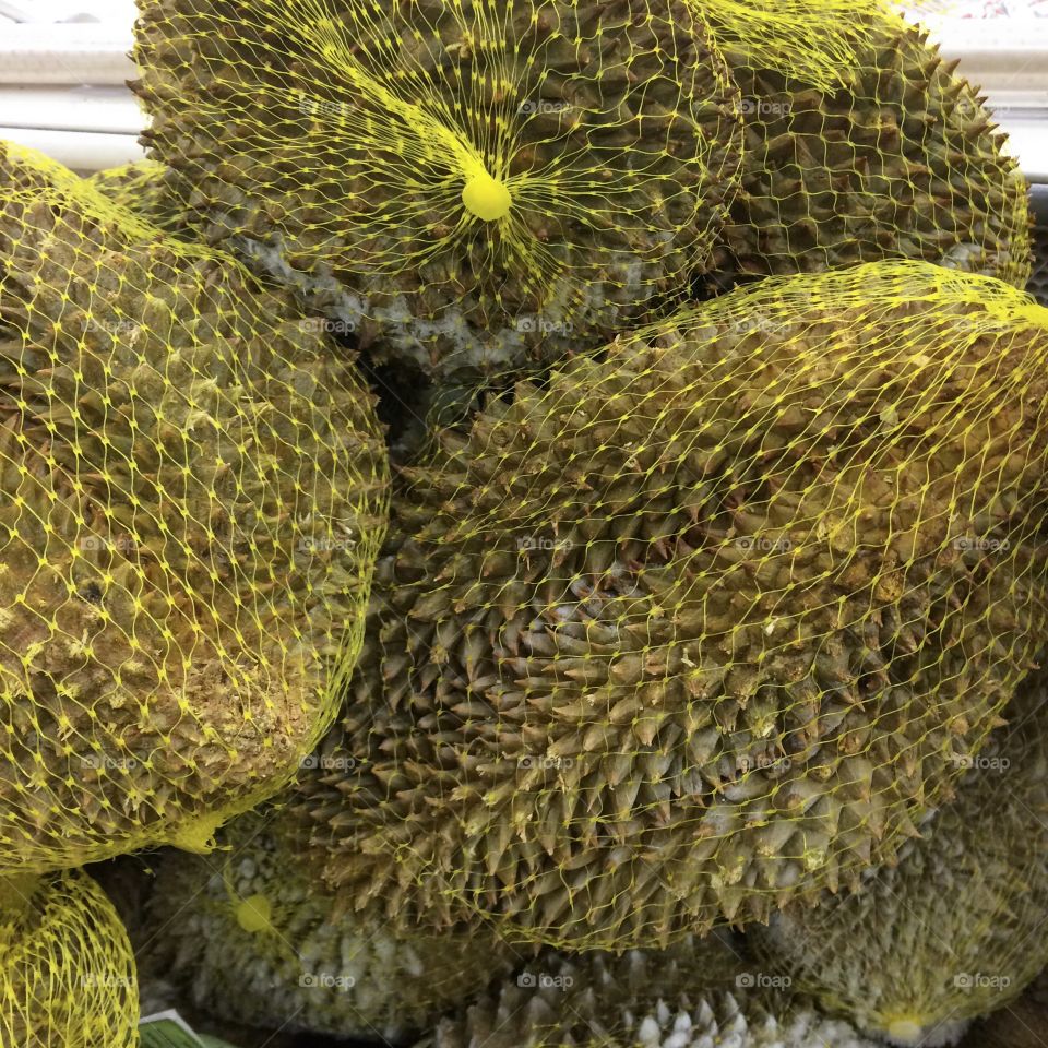 Durian fruit packaged in yellow mesh 