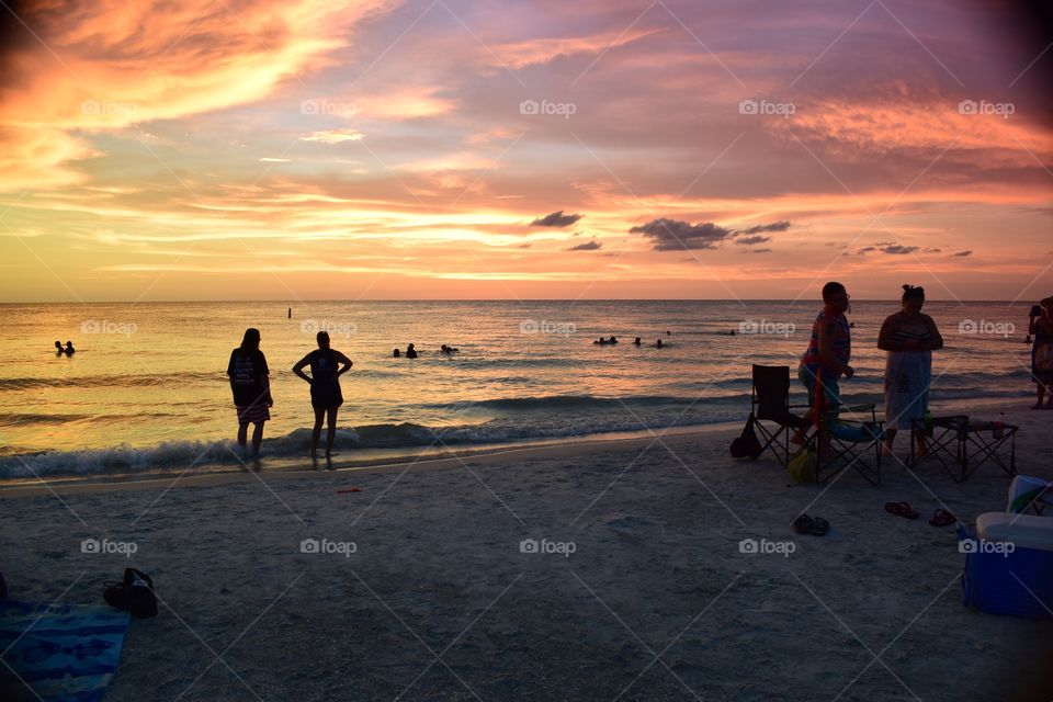 Tampa bay Floridians mull around the beach as a beautiful skyline takes shape.