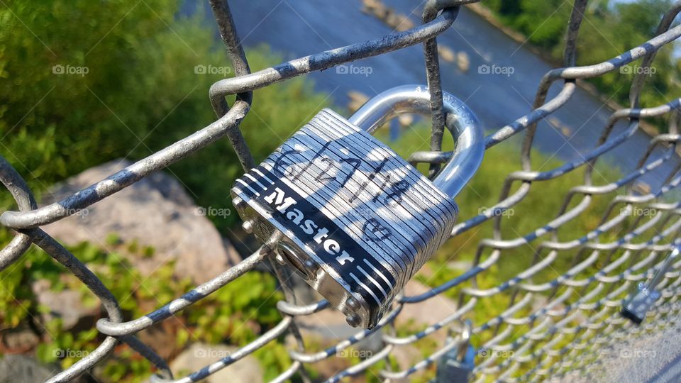 a lock for love with the date on it Overlook in Mississippi River on a chain link fence