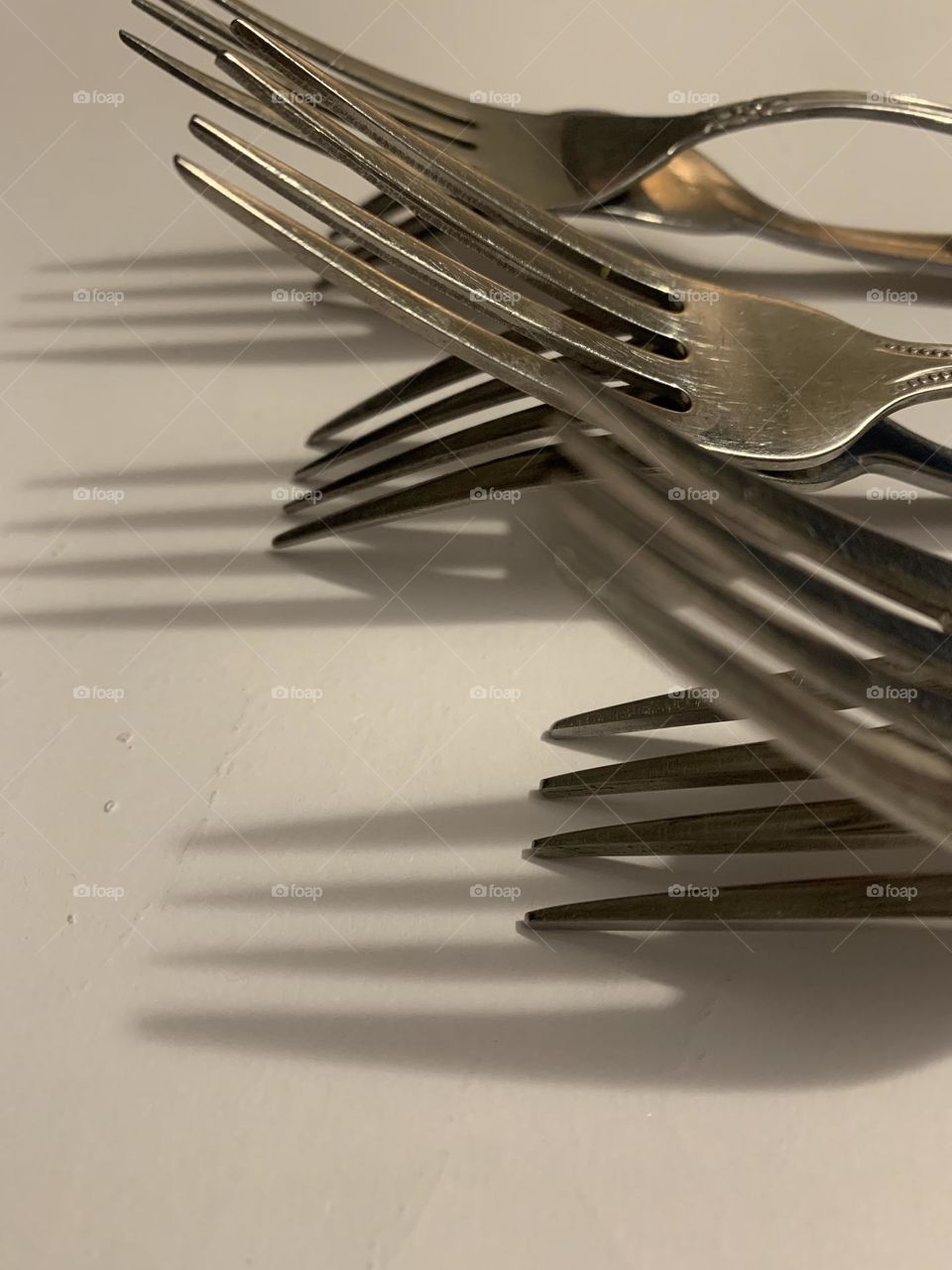 6 forks in rows casting shadows 