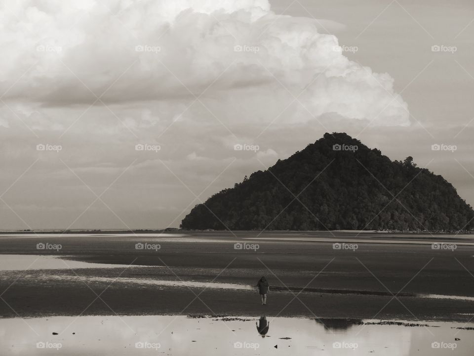 Black and white landscape of a beach and a island nearby. 