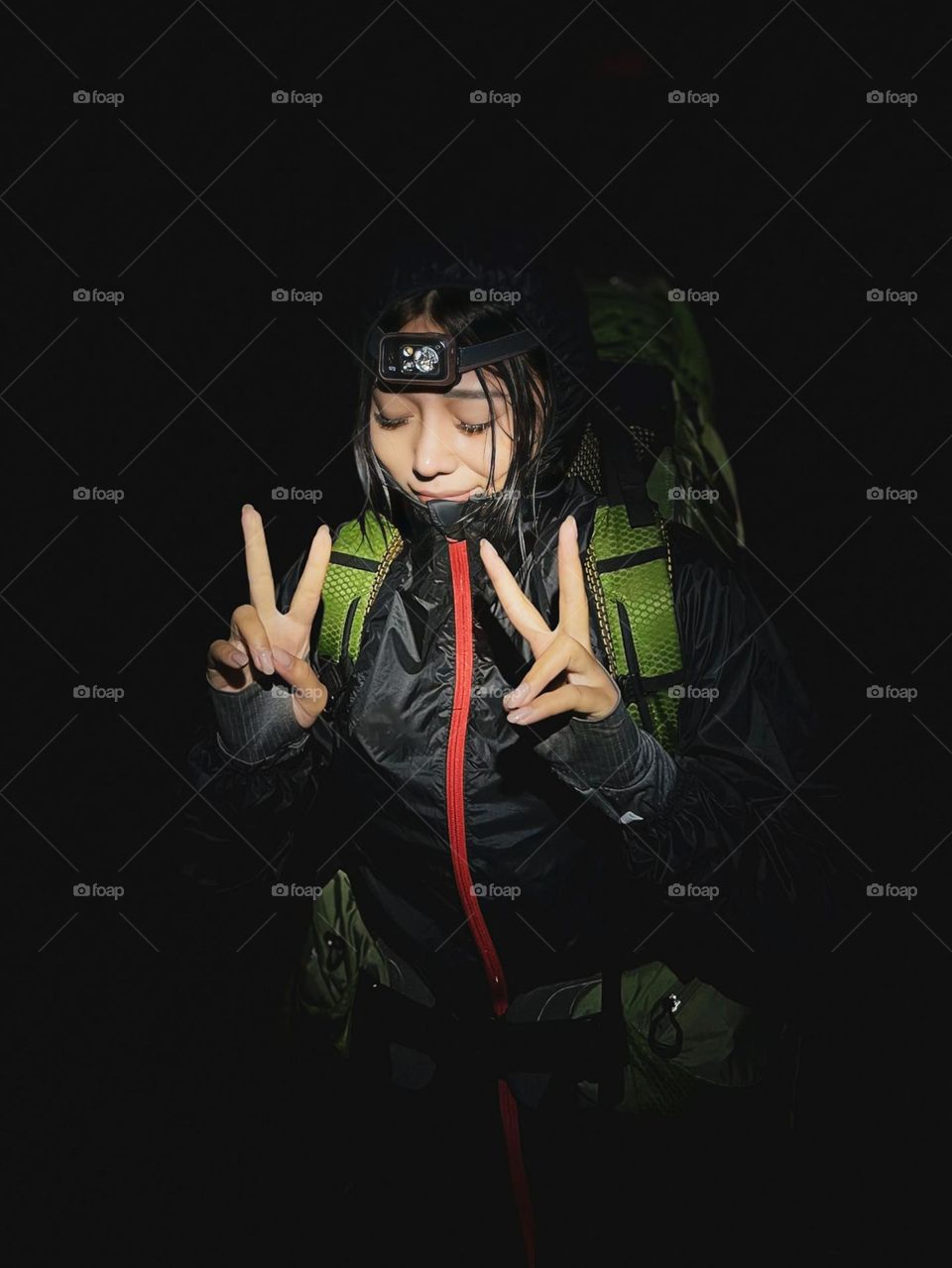 Portrait of a young woman mountain climber in the pitch black night