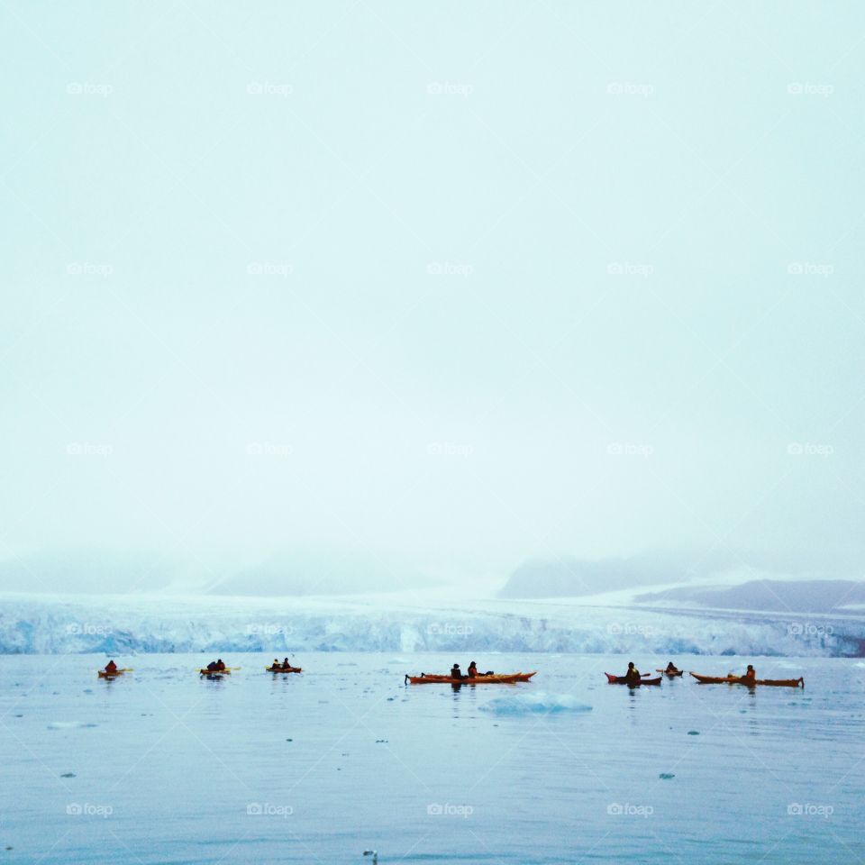 Kayaking near a glacier along the coastline of Spitsbergen, Svalbard. 