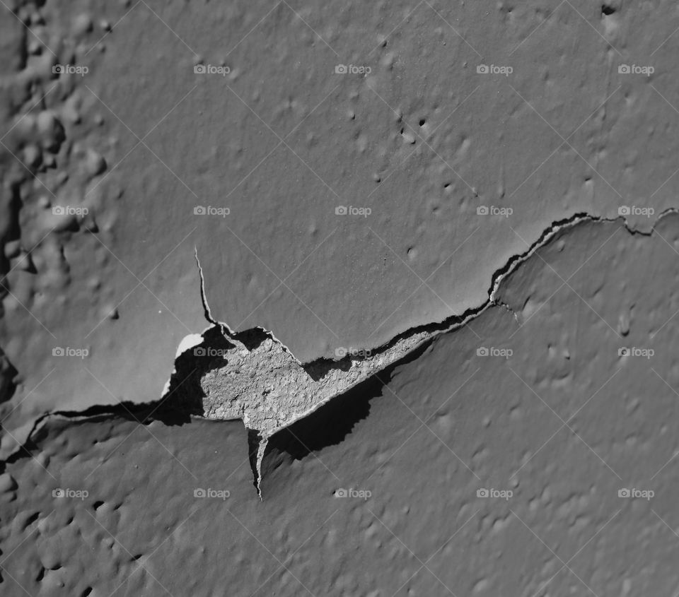 Fine details of peeling and flaking paint from an old concrete wall. 