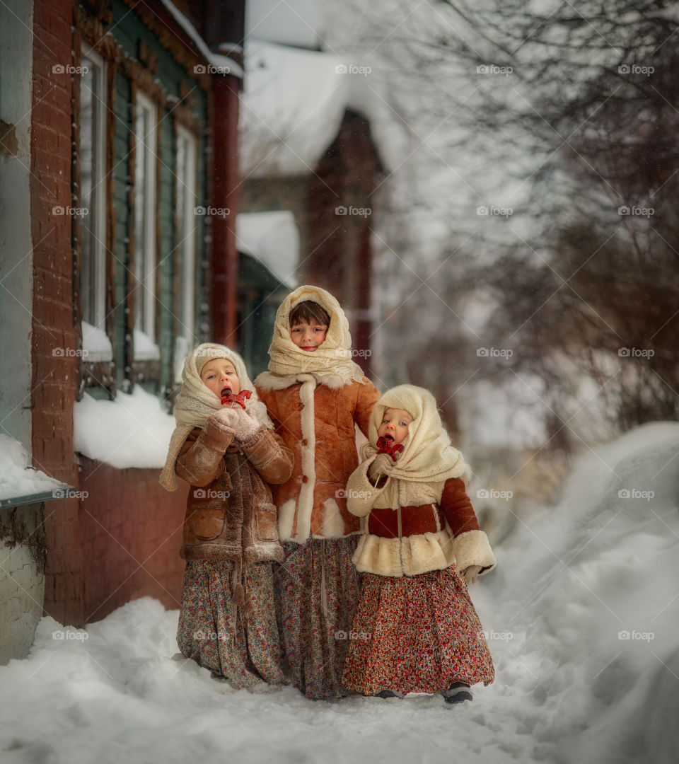 Three little girls with lollipops vintage portrait at winter day