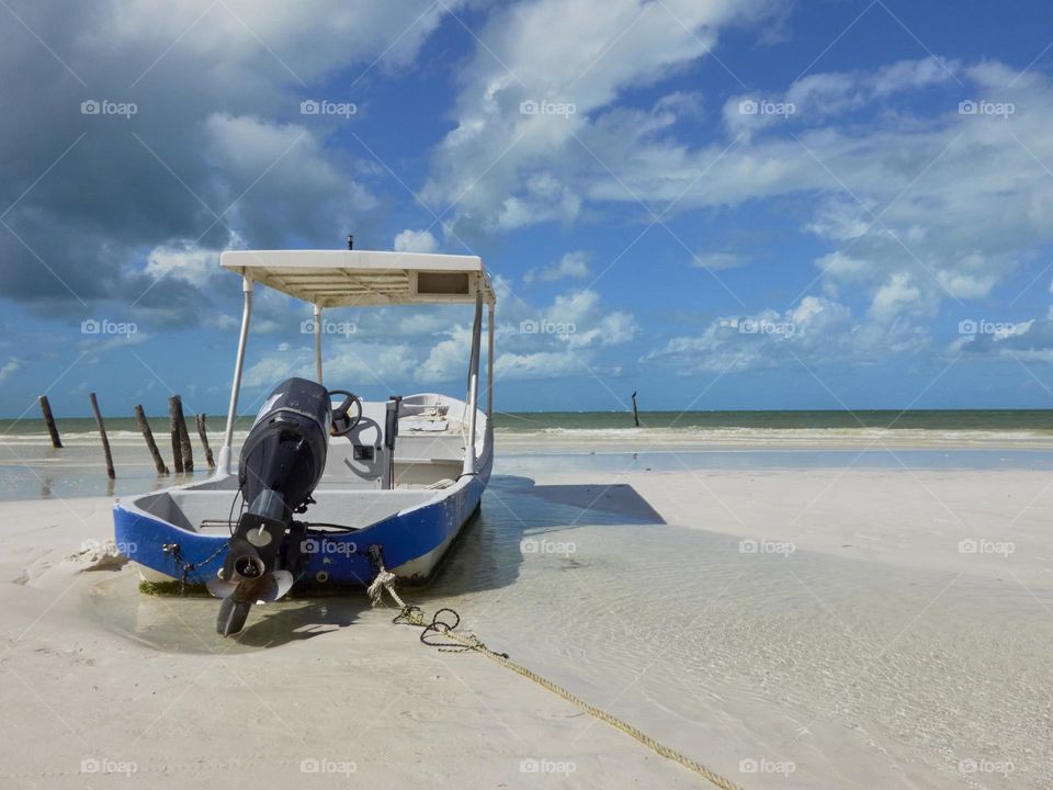 paisaje de un barco en la arena de una playa paradisiaca en solitario